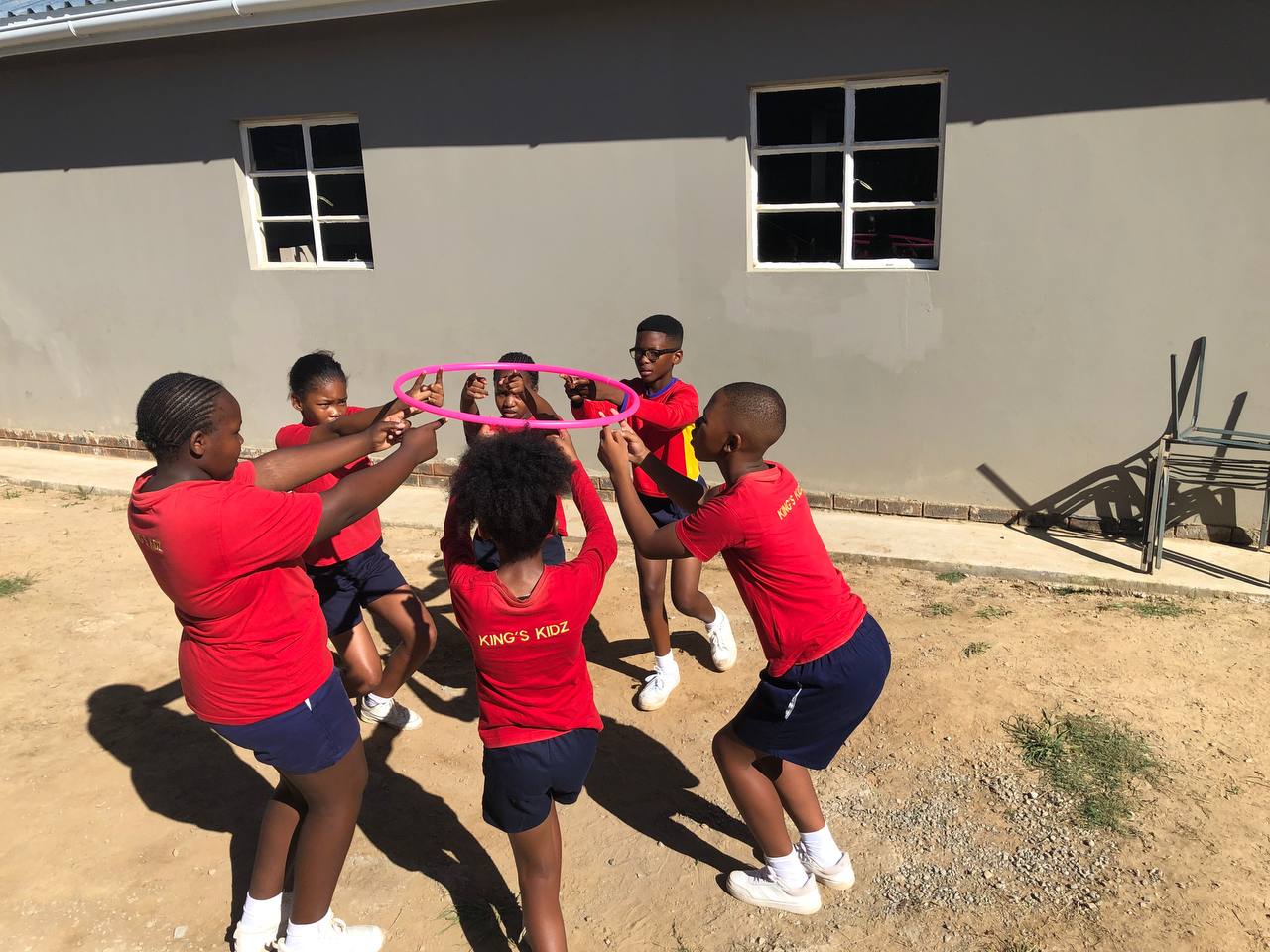 School learners working together in a group hoop challenge
