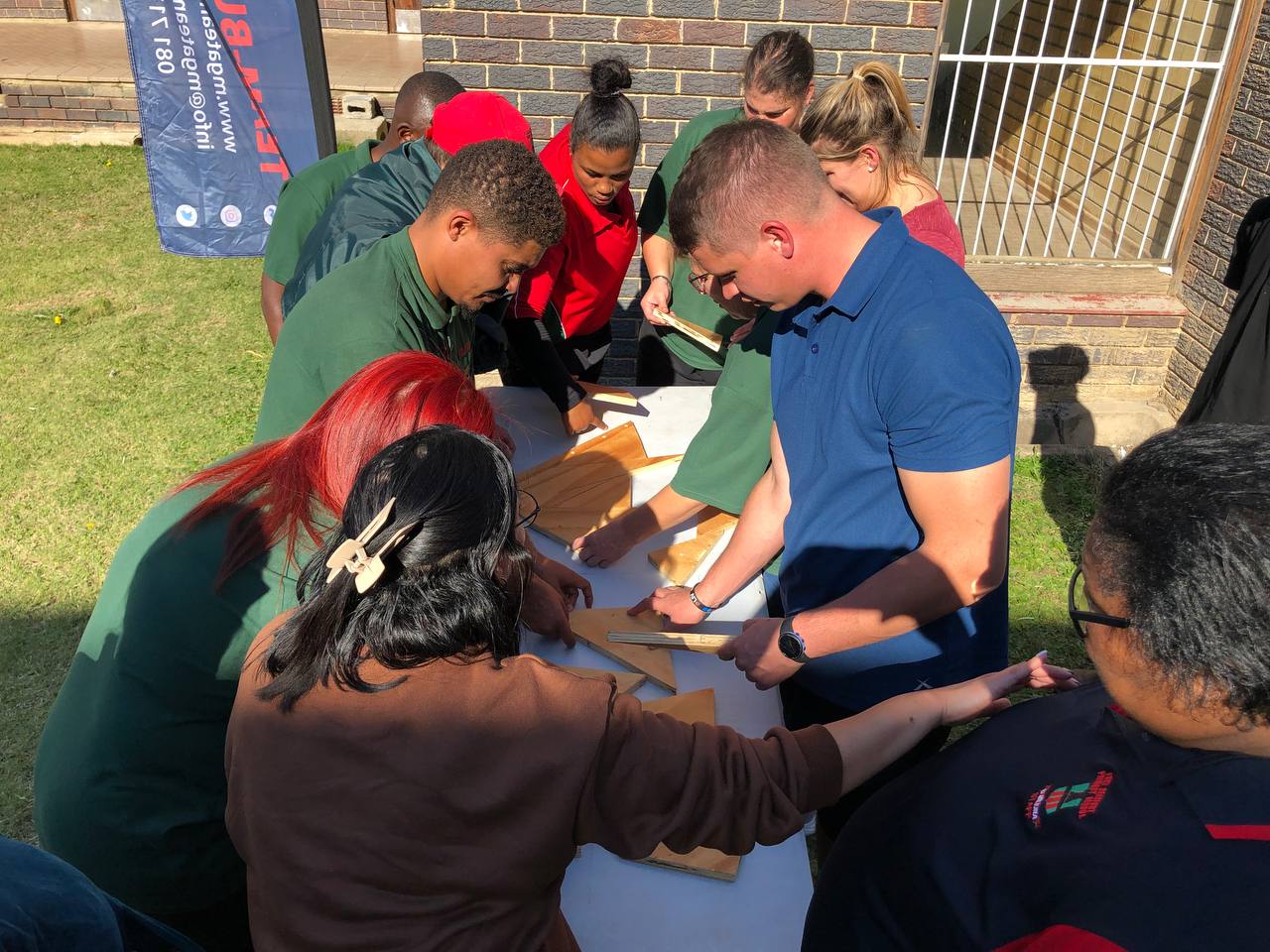 South African workplace team completing an MGA problem-solving challenge outdoors